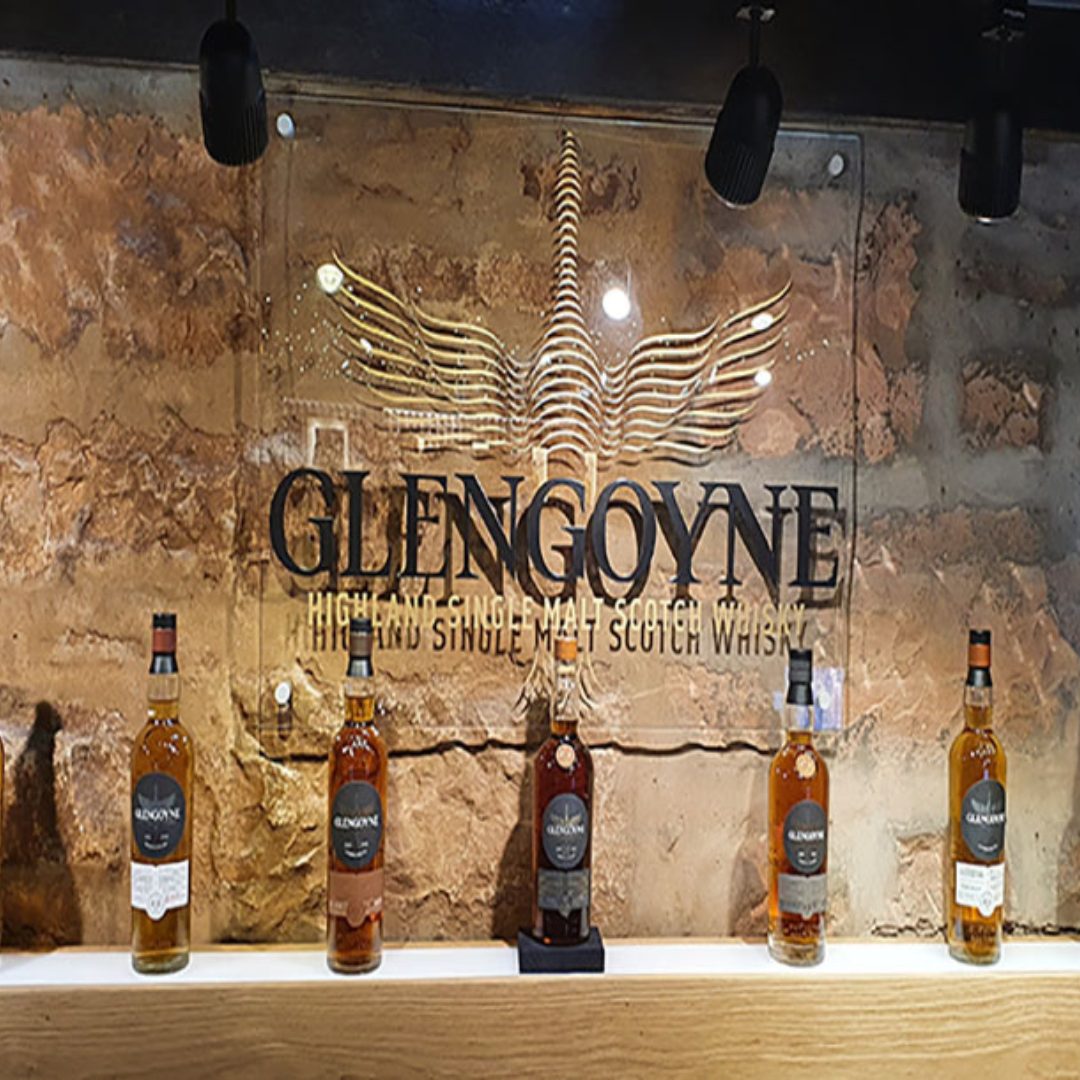 Glass wall printed with Glengoyne Distillery with whisky bottles sat in front of it
