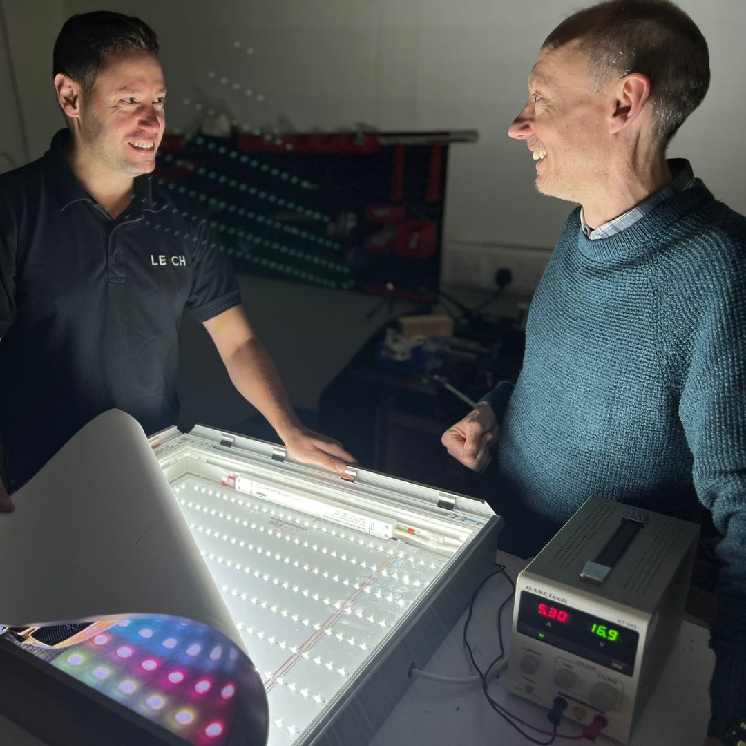 Two Leach team members stood next to each other working together